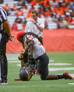 A Maryland player kneels on the Carrier Dome turf while tight end Andrew Isaacs was carted off the field. As it turns out, Isaacs will miss the rest of the season with a dislocated knee. 