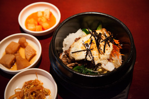 Mok Hwa’s beef bi bim bap meal contains minced beef, mushrooms, carrots, fried egg, bean sprouts and is topped with seaweed strips. The dish is served over a bed of white rice that is covered in the beef.                                        