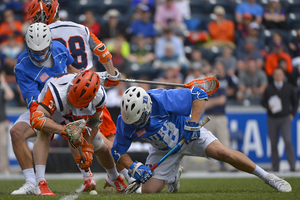 SU's Ben Williams (left) scraps with Duke's Kyle Rowe (right) for a faceoff near midfield. Williams uncharacteristically struggled, only capturing 11 of his 29 attempts at the X, but the Orange overcame it.