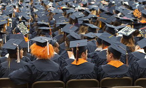 Syracuse University students sit on the turf at the Carrier Dome during the 2013 commencement ceremony.
