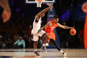 Michael Gbinije dribbles around a Connecticut player. The SU point guard finished with seven assists and six steals.
