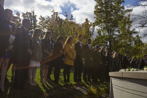Last year's Remembrance Scholars gather in front of the Remembrance Wall at Syracuse University for the 2015 Rose Laying Ceremony.