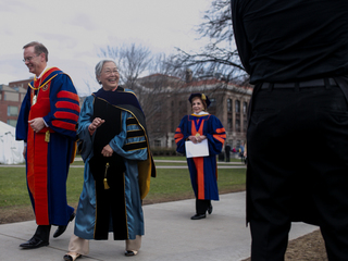 The chancellor's wife, Ruth Chen, waves at a friend as she and Kent Syverud walk to the inauguration reception on April 11, 2014.