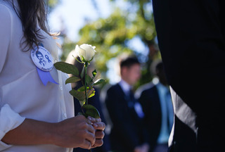 Remembrance scholar Isabel Firpo, an industrial and interaction design major, holds a rose during the Remembrance Week Rose Laying Ceremony on Friday.