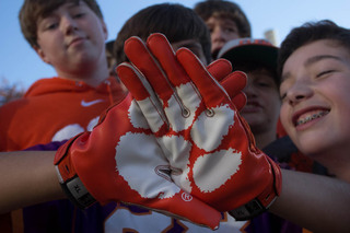Young fans look at gloves that feature the Tigers' logo, a paw print.
