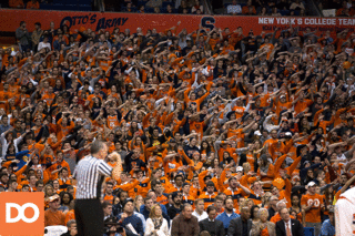 Members of the SU student section waves their arms back and forth as a Demon Deacon attempts free throws.