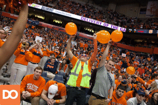 Syracuse fans seated at the front of the student section hold balloons.