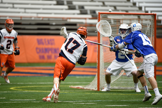 Donahue unleashes a shot on goalie Luke Aaron as freshman defender Greg Pelton tries to get a stick in.