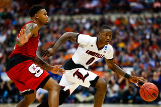 The Cardinals' Terry Rozier, right, cruises past N.C. State's Trevor Lacey, left, while looking for an opening to pass.