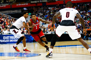 NCSU's Trevor Lacey (1) fights his way past Louisville's guards early in the first half. 