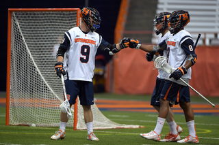 Tim Barber fist-bumps teammates after the Orange scored a goal. SU scored the first 15 on the night. 