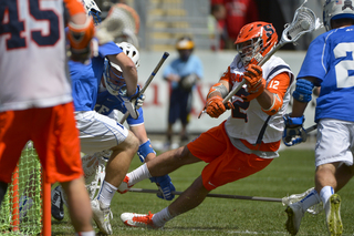 Syracuse midfielder Derek DeJoe attempts an off-balance shot from in front of the cage.